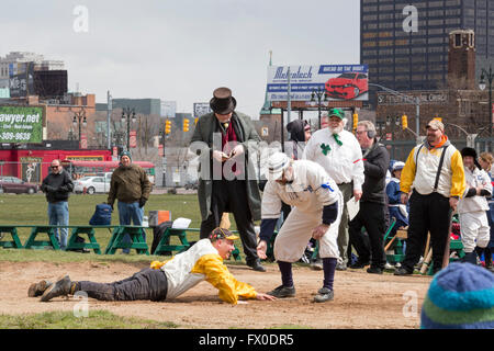Detroit, Michigan USA - 9 April 2016 - A vintage base ball game, with rules and uniforms from the 1860s, is played to say farewell to Navin Field. As Navin Field and later Tiger Stadium, the field was home to the Detroit Tigers from 1912-1999. Since then, the field has been maintained by volunteers; it will now be redeveloped as a retail and residential complex with a playing field for youth sports. After sliding into home, a player gets a hand from the opposing catcher. Credit:  Jim West/Alamy Live News Stock Photo