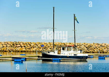 Simrishamn, Sweden - April 1, 2016: One sailboat moored in the marina. It has two masts has a Swedish flag hoisted in one of the Stock Photo