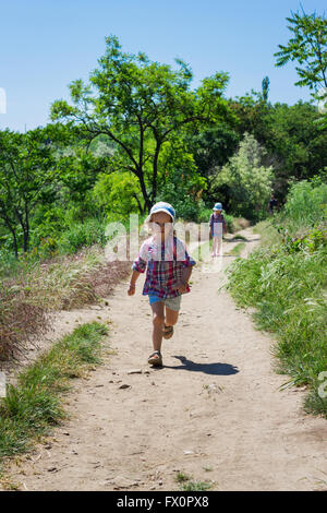 Little sisters (3 and 4 years) go hiking with backpacks. Selective focus. Stock Photo