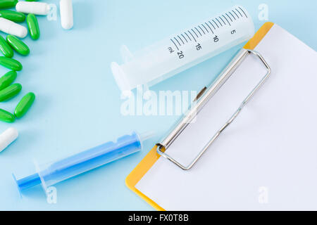 Medical conceptual picture with pills, injection, empty clipboard sheet. Stock Photo