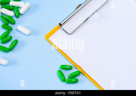 Medical conceptual picture with pills, injection, empty clipboard sheet. Stock Photo