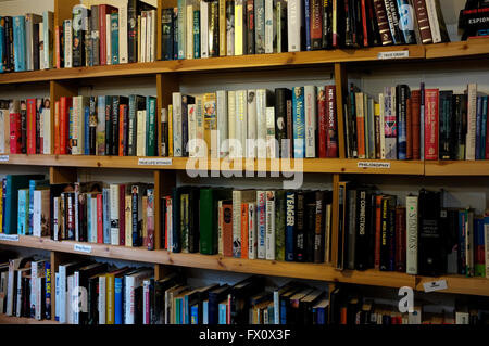 rows of secondhand fiction and non fiction books on wooden shelves in east kent uk april 2016 Stock Photo