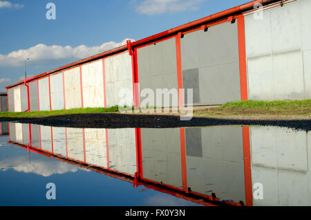 A lot of garages, puddle with reflection. Stock Photo