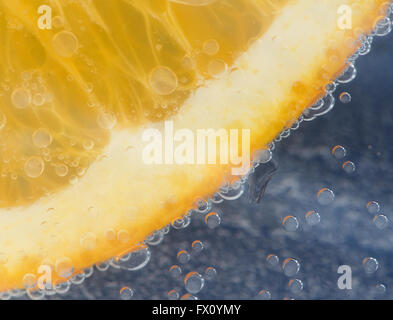 Orange in water on blue background and bubbles. Stock Photo