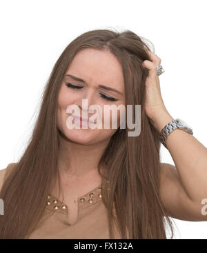 A woman looks worried with her hand in her hair Stock Photo
