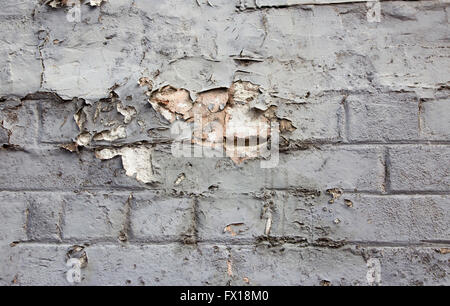 Weathered old eroded  peeling  grey painted  cement rendered  clay brick wall   would be  ideal for grunge backgrounds. Stock Photo