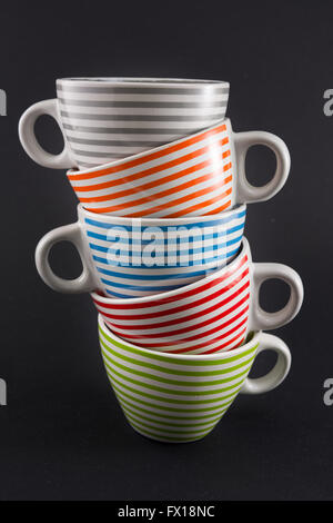 Four tea cups stacked on black background Stock Photo