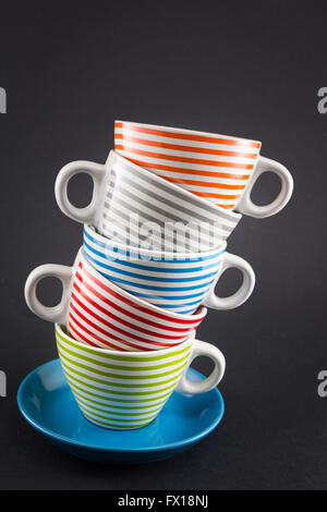Four tea cups stacked on black background Stock Photo