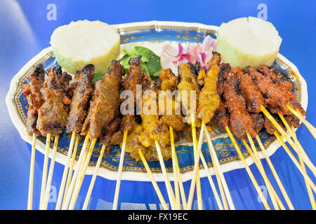 Satay Chicken Beef and Mutton with Cucumbers Onions and Rice Cake Closeup Stock Photo