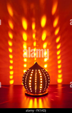 Traditional japanese lantern with candle inside showing patterns on the wall Stock Photo