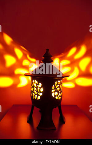 Traditional japanese lantern with candle inside showing patterns on the wall Stock Photo