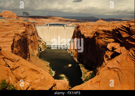 Glenn Canyon Dam and bridge over the Colorado River.  A concrete dam that causes Lake Powell seen just beyond the dam. Stock Photo