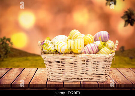 Composite image of easter eggs in basket Stock Photo