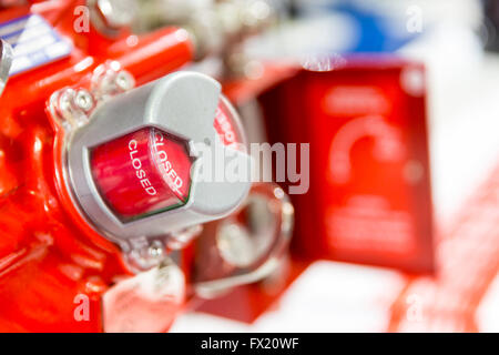An red button indication that it is closed on a machinery. Equipment of a bigger machine tool. Stock Photo