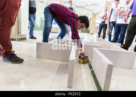 Sofia, Bulgaria - April 5, 2016: A student is helping his self-made robot in a labyrinth during an open competition among school Stock Photo
