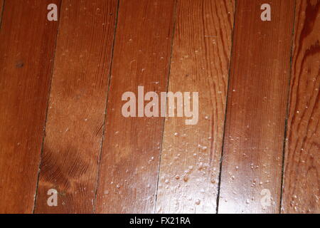 Knocked and battered varnished wooden floorboards Stock Photo