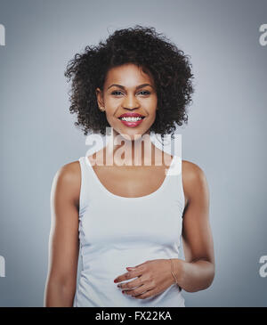 Portrait of smiling happy woman, black woman on grey background, big black curly hair