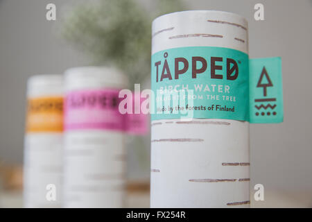 Tapped Birch water cartons on a wooden kitchen table in natural light. Stock Photo