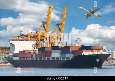 Industrial Container Cargo freight ship with working crane in shipyard Stock Photo