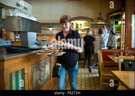A waitress in the Beisl Cafe Vianna serving Vienna Schnitzel Stock Photo