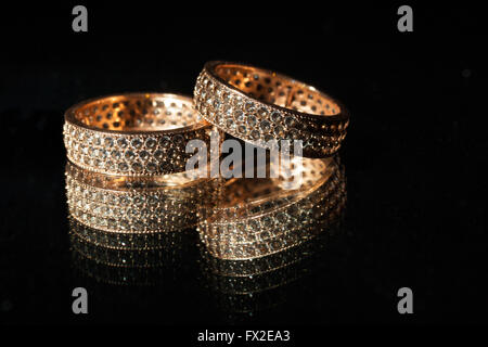 Pair of wedding rings reflected in a mirror, on a black background Stock Photo