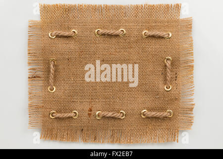 Frame made of burlap with a fringe and rope, on a white background Stock Photo