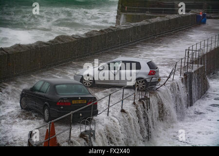 Mousehole, Cornwall, UK. 10th April 2016. UK Weather. The latest storm to hit Cornwall with 65mph winds and a high spring tide swamp cars on Mousehole Harbour Wall, almost pushing one of them into the harbour itself. Credit:  Simon Maycock/Alamy Live News Stock Photo