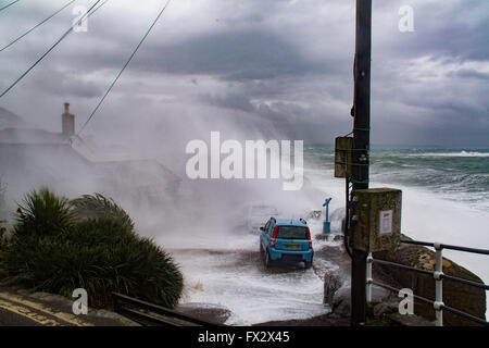 Mousehole, Cornwall, UK. 10th April 2016. UK Weather. The latest storm to hit Cornwall with 65mph winds and a high spring tide swamp cars on Mousehole Harbour Wall, almost pushing one of them into the harbour itself. Credit:  Simon Maycock/Alamy Live News Stock Photo