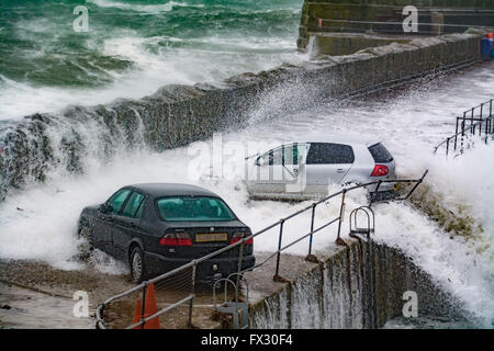 Mousehole, Cornwall, UK. 10th April 2016. UK Weather.  The moment the force of the sea almost pushes this car into the harbour at Mousehole, during this morning huge waves. Credit:  Simon Maycock/Alamy Live News Stock Photo