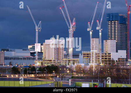 New skyscrapers in the International Quarter of the Queen Elizabeth Olympic Park stand out against a stormy twilight sky Stock Photo