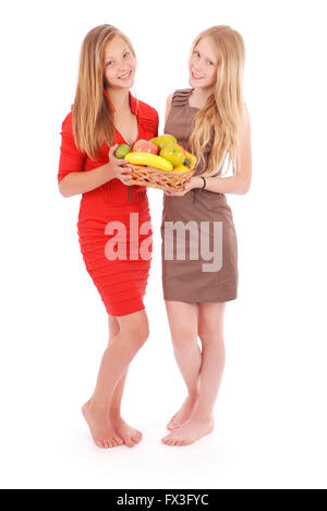 Two young girl with a fruit basket isolated on white Stock Photo