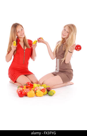 Two girls holding fresh fruits isolated on white Stock Photo