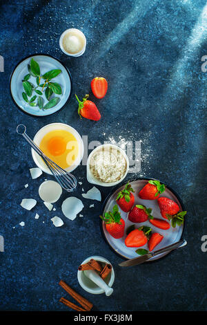 Baking ingredients, strawberry and cinnamon on a marble background Stock Photo