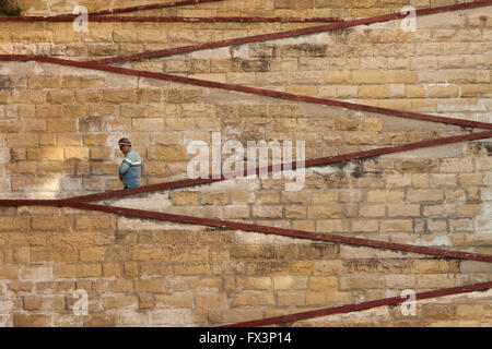 Man walking down the stairs in Senglea, Malta. Stock Photo