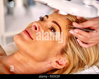 Middle-aged woman in a retracting eyebrows spa. Stock Photo