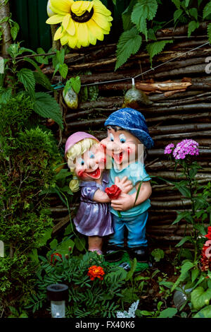 Nice decorative figurines of jolly fellows couple in summer garden Stock Photo