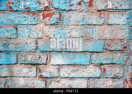 Cracked damaged brick wall painted in blue color texture background. Stock Photo