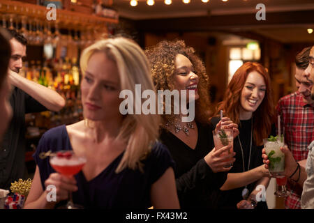 Group Of Friends Meeting For Evening Drinks In Cocktail Bar Stock Photo
