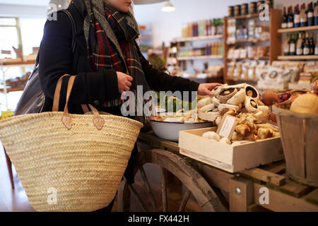 Close Up Of Woman Shopping For Produce In Delicatessen Stock Photo