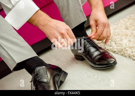 Man tying shoelaces shoes in natural light Stock Photo