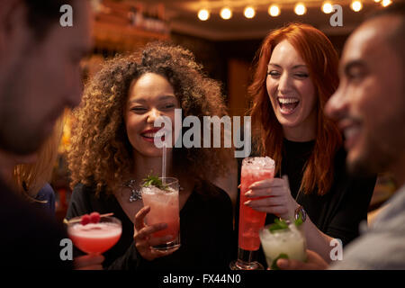 Group Of Friends Meeting For Evening Drinks In Cocktail Bar