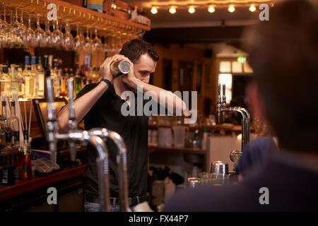 Barman Making Cocktail In Bar Using Shaker Stock Photo