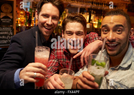 Male Friends Meeting For Evening Drinks In Cocktail Bar Stock Photo