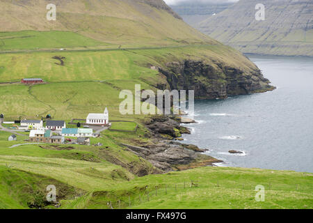 Typical landscape on the Faroe Islands, with green grass, rocks and water close to Vidareidi Stock Photo