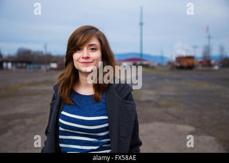 Modern, trendy, hipster girl in an abandoned train yard at dusk in this fashion style portrait. Stock Photo