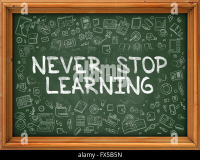 Never Stop Learning - Hand Drawn on Green Chalkboard. Stock Photo