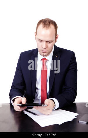 Serious American Businessman in red tie at the table working on Stock Photo
