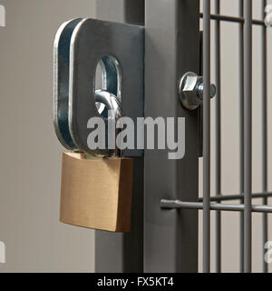 Padlock on a hasp securing a wire fence room Stock Photo