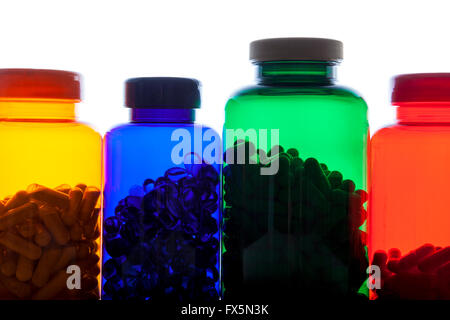 Colourful pill bottles full of pills against white background Stock Photo