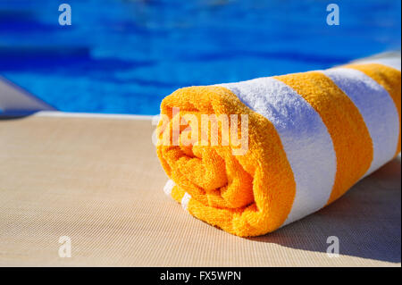 orange with white towel on a sun lounger background of pool Stock Photo